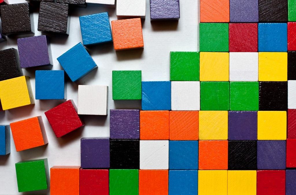 Scattered wooden blocks forming an ordered grid, illustrating an autism or ADHD diagnosis bringing clarity